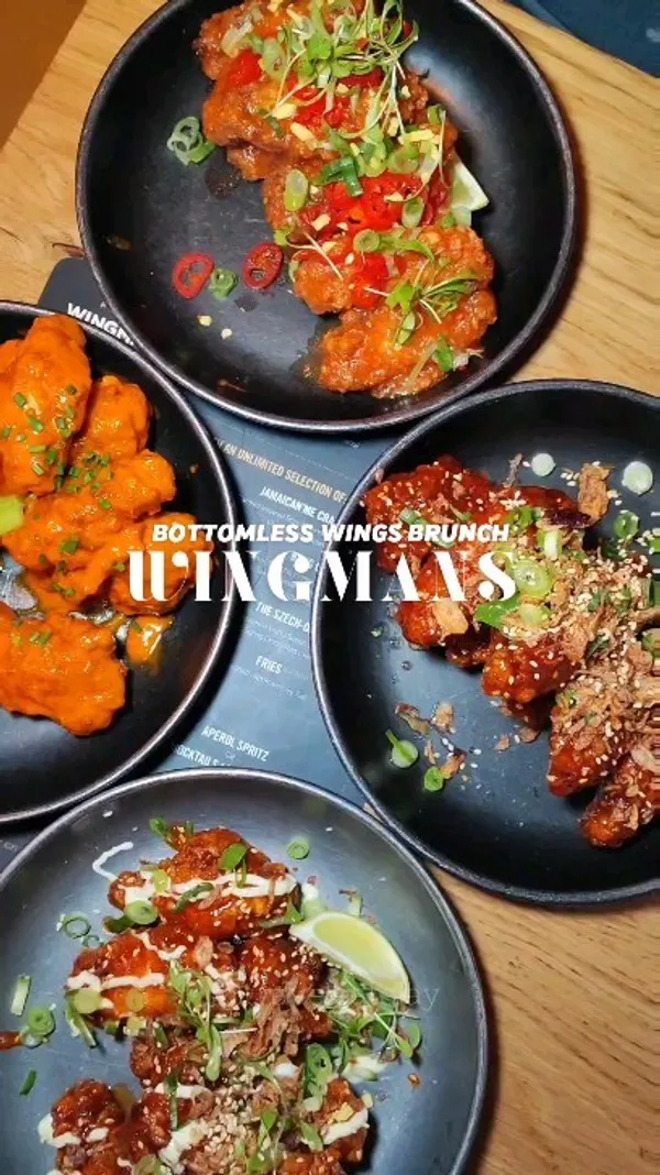 The video showcases a bottomless wings brunch at Wingmans in Soho, London. It features various types of chicken wings with different sauces and toppings, accompanied by Aperol Spritz and other drinks. The presentation emphasizes the variety of flavors and colorful garnishes, with overhead shots focusing on the platters of wings.  No specific dietary information is provided.