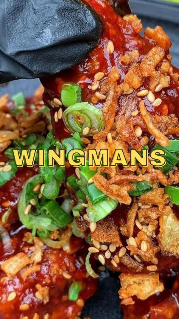 The video showcases Wingmans Chicken's Express Lunch Menu. The setting is the restaurant itself, showing both the kitchen and dining areas. Food items featured include various chicken wings (in a sweet and spicy sauce), a burger with fried chicken patties, and french fries.  The presentation emphasizes the appetizing appearance of the food with close-up shots and attractive plating. No specific dietary information is provided. The main focus is on the food and the lunch deal.