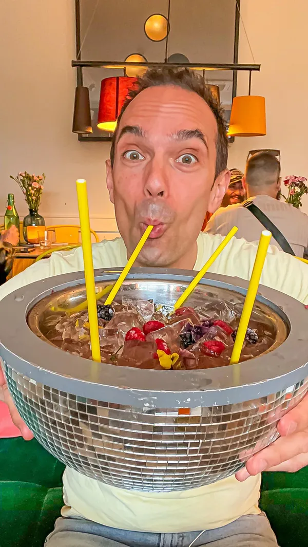 This video showcases a hidden cocktail bar in London, accessible through a distinctive yellow door.  The video highlights the bar's quirky interior, featuring board games, eclectic decor, and a unique atmosphere.  Food items like halloumi fries with smoked paprika aioli and chilli jam are presented, along with cocktails named after films, such as 'La La Land' served in a milk bottle and 'Dirty Dancing' served in a disco ball. The main focus is on creating an exciting and fun experience for the viewer, emphasizing the bar's unique ambiance and offerings.