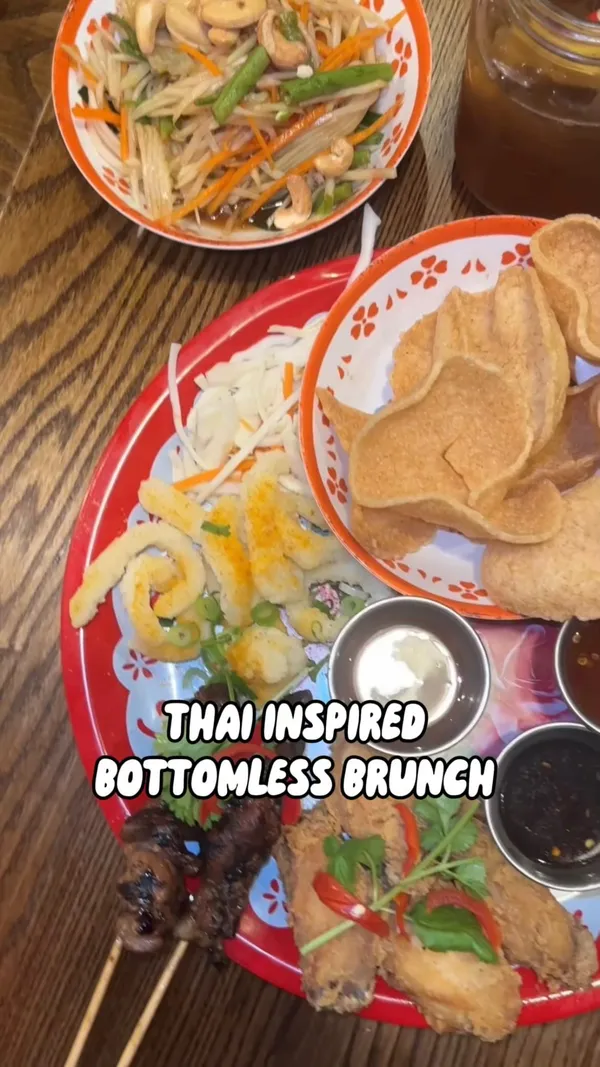 This video showcases Rosa's Thai restaurant, highlighting their bottomless brunch. The video presents various Thai dishes such as Pad Thai, green curry, spring rolls, and other appetizers, alongside various drinks. The food is presented on colorful plates, showcasing a vibrant aesthetic. No dietary information is explicitly mentioned. The video primarily focuses on showcasing the food and drinks offered during the bottomless brunch.