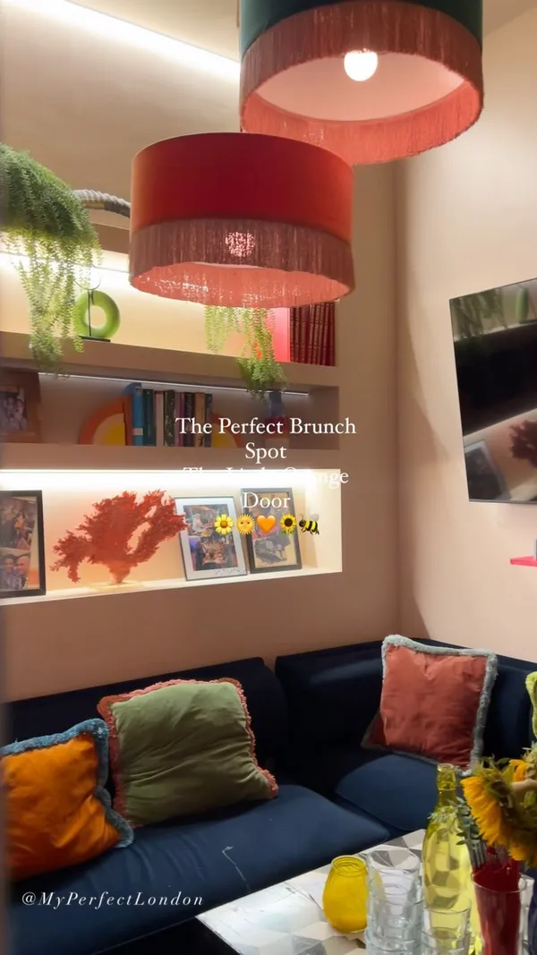 The video showcases The Little Orange Door, a cafe in Clapham. It highlights various brunch items, including buttermilk pancakes with berries and orange segments, a fried chicken sandwich, and cocktails. The presentation is visually appealing, with a focus on close-up shots that highlight textures and colors. No dietary information is explicitly mentioned. The main focus is a promotional showcase of the cafe's brunch offerings and atmosphere.