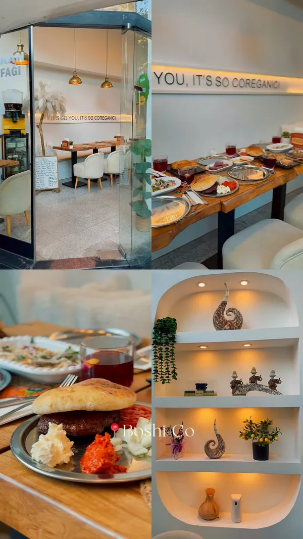 The video showcases a restaurant called Boshi-co Balkan Sofrası. It features shots of the restaurant's exterior and cozy interior decor. Several Balkan dishes are shown on a large wooden table, including what appears to be a pljeskavica (Balkan burger) with sides, some kind of pastry (burek or similar), cured meats, and salads. The video also includes brief shots of a baby in a stroller at the table and a woman eating. The overall vibe is warm and hospitable.
