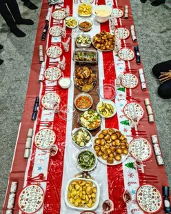 Festive Christmas feast with traditional turkey and red meat dish, surrounded by holiday decor and a Christmas tree.
