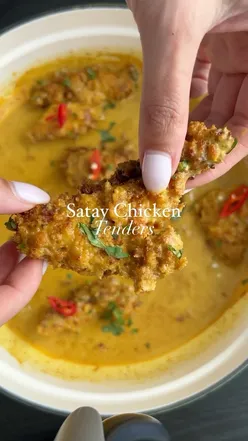 Air-fried satay chicken tenders with egg fried rice, garnished with coriander, chili, and lime; 560 calories, 36g protein.