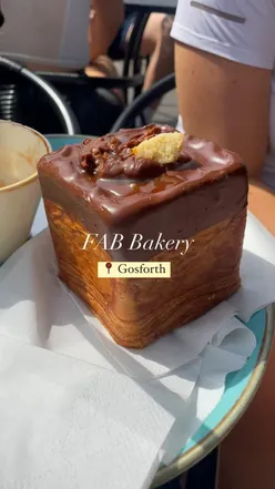 FAB Bakery in Gosforth with queues outside, featuring Millionaires Shortbread Croissant Cube, Almond Croissant, and Vegan Pastry.