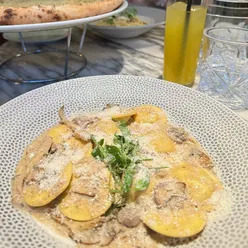 Truffle ravioli with mushroom sauce at Cibo Wilmslow, paired with cheesy garlic bread; vegetarian and halal options available.