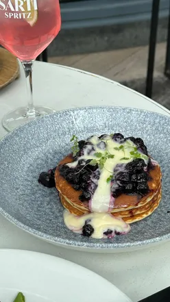 Wimbledon's 601 Queens Road rooftop brunch with avo toast, steak & eggs, pancakes with lemon curd labneh, and Sarti Spritz.