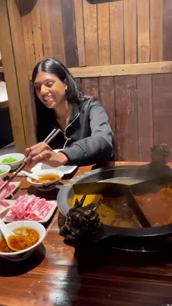 Steaming hot pot with fresh vegetables and meats at Dragon Inn Club, London's top hot pot destination.