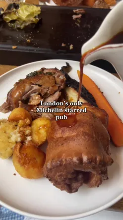 Golden roast potatoes on a plate, part of a Michelin-star dinner in London, capturing the essence of gourmet cuisine.