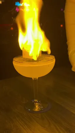 Bartender crafting fiery cocktails at a lively East London restaurant, perfect for a vibrant date night.