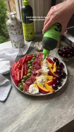Colorful snack plate featuring cherries, burrata, and charcuterie for summer gatherings.