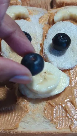 Valentine's toast shaped like Bluey with strawberry heart and blueberry mouth, perfect for kids' breakfast.