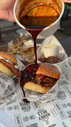 Juicy London burger with toppings on a wooden board, highlighting top burger spots in London for food lovers.