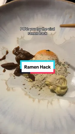 A bowl of ramen topped with kewpie mayo and a vibrant egg yolk, showcasing a delicious ramen hack.