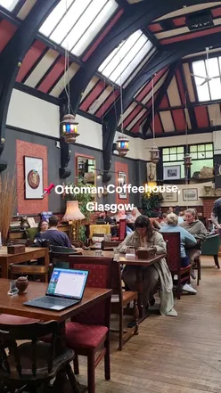 Barista pouring latte art into a coffee cup at Ottoman Coffeehouse, Glasgow. Perfect spot for coffee lovers.