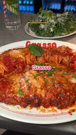 Delicious Chicken Parm at Grasso in Soho, showcasing a huge portion with mozzarella sticks, perfect for food lovers.