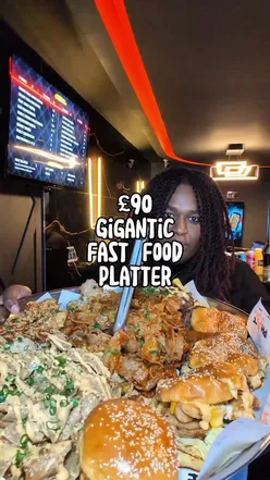 Massive fast food platter with burgers, fries, and drinks at Phatforlife, Bethnal Green, London. Perfect for group dining.