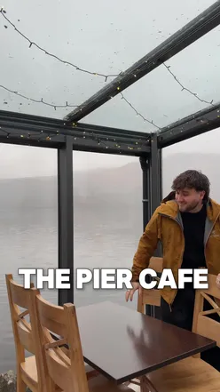 View of Loch Katrine from The Pier Cafe, Stirling, with misty pine forests; scenic spot near Glasgow, Scotland.