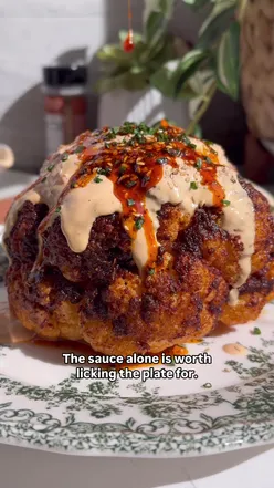 Spicy roasted cauliflower with creamy skyr tahini sauce, topped with sesame seeds, chives, and salsa macha, inspired by Coliflor Oliva.